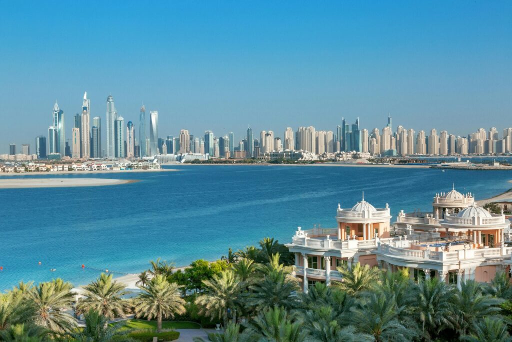 Panoramic view from The Palm Jumeirah in Dubai with luxury villas in the foreground, turquoise waters, and the modern skyline in the background – ideal lifestyle for those seeking a residence visa in Dubai.