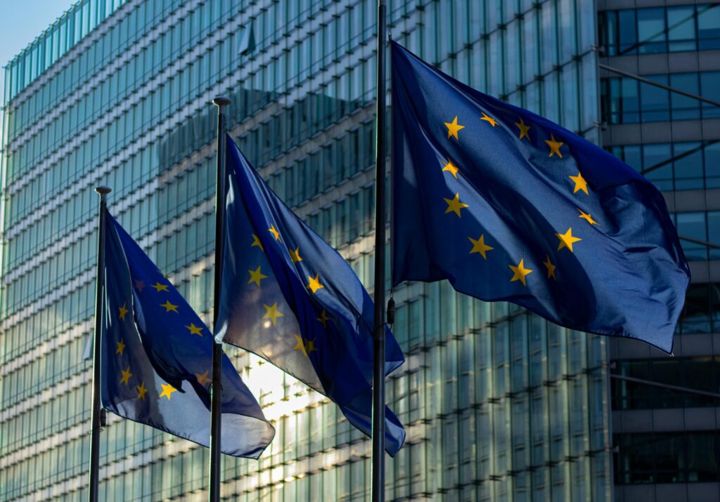 European Union flags outside modern building representing compliance with DAC7 tax directive