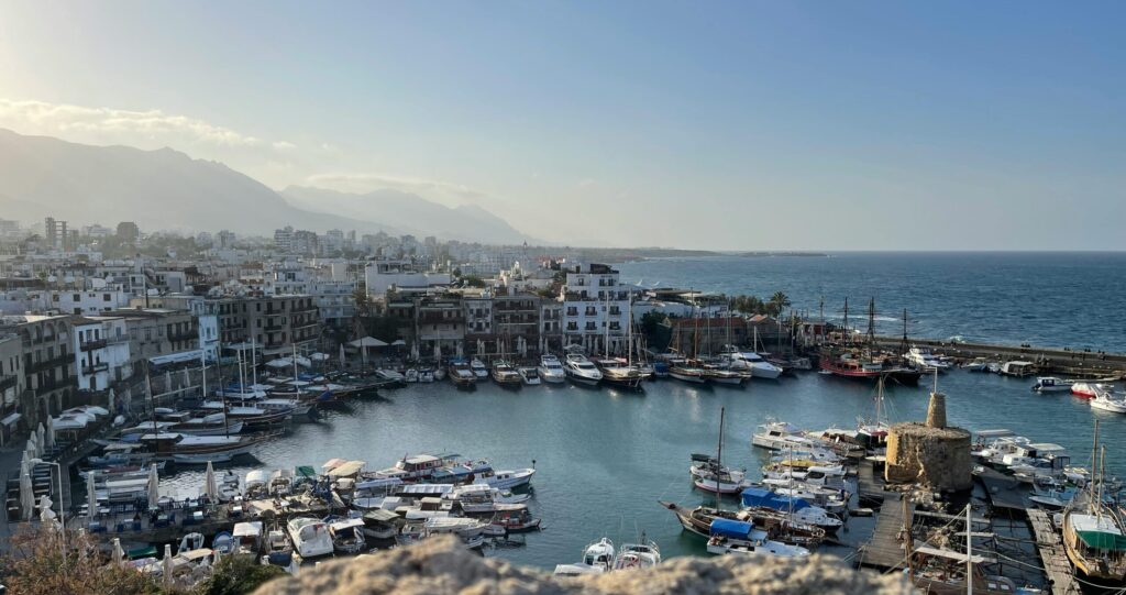 Scenic view of Girne harbor in Cyprus with boats and Mediterranean Sea, highlighting lifestyle benefits alongside low taxes in Cyprus.
