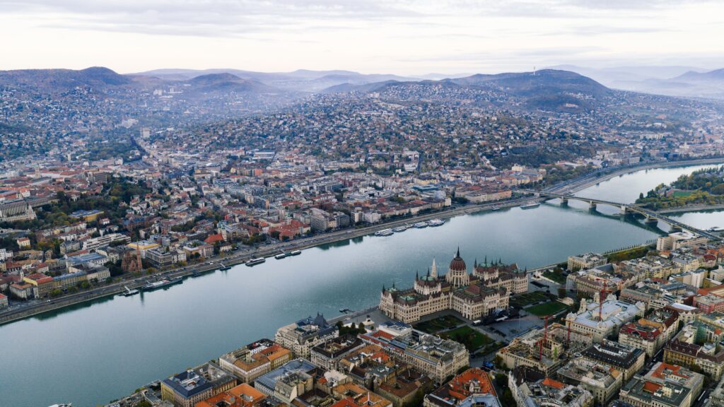 Aerial view of the Danube dividing Budapest with Hungarian Parliament and hills