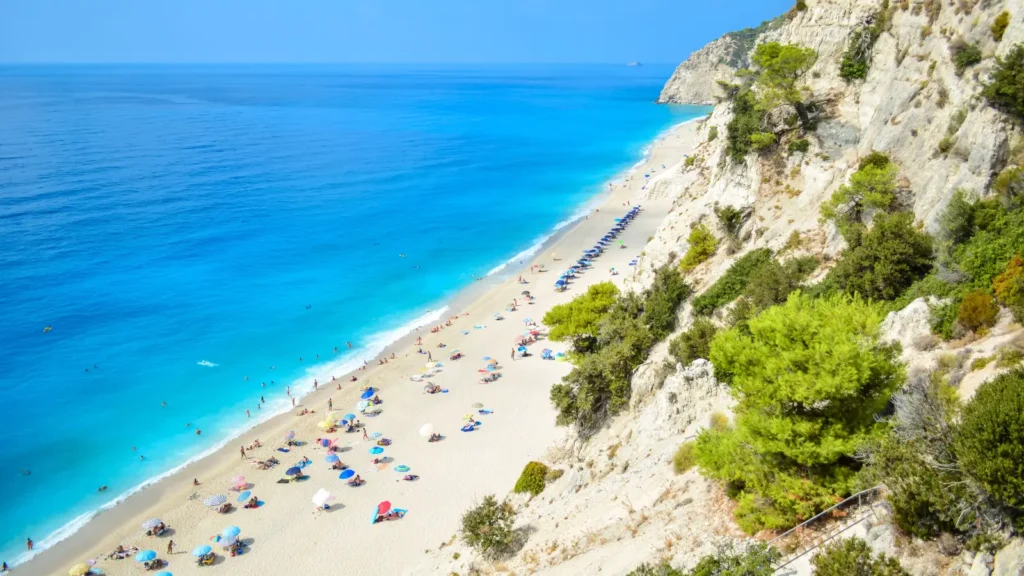 Golden sandy beach and deep blue Ionian sea below cliffs in Lefkada