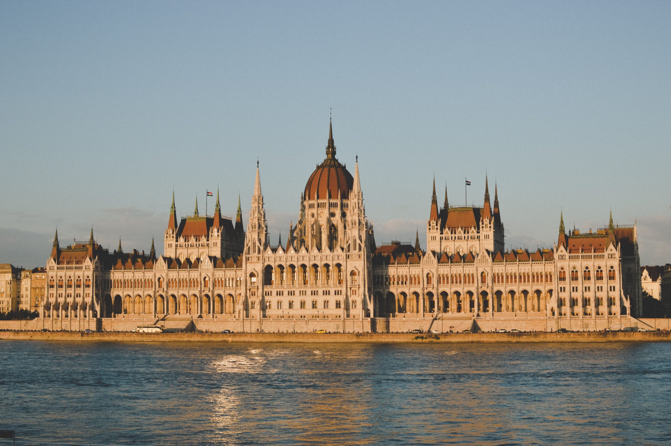 Hungarian Parliament Building lit by golden sunset light beside the Danube river
