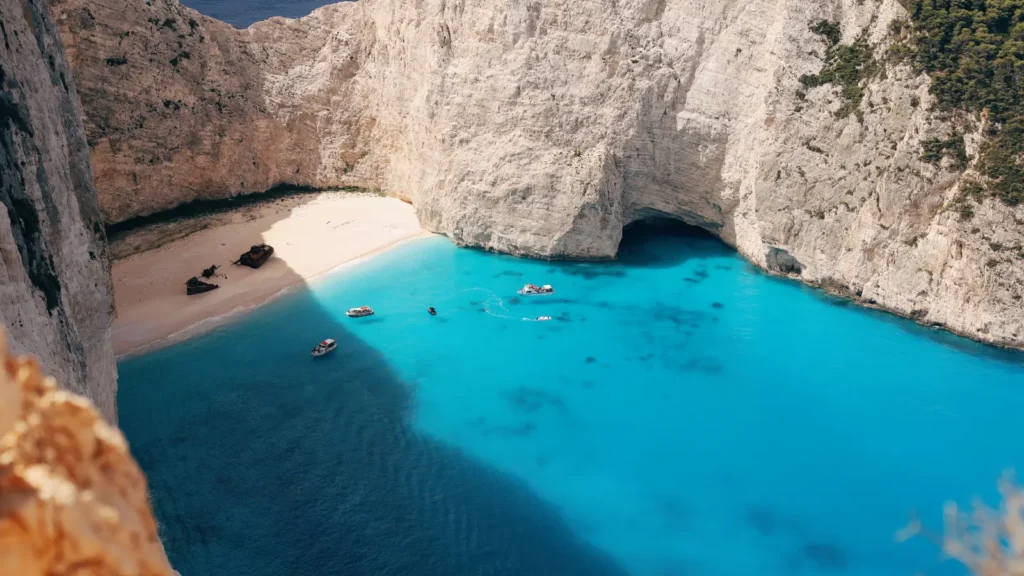 Panorama of Navagio shipwreck cove with white cliffs and clear blue water in Zakynthos